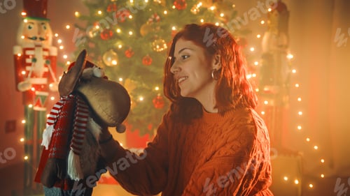 Preview: Girl plays with soft toys under the christmas tree