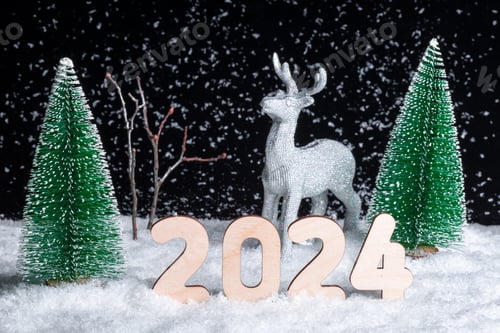 Preview: Christmas card. A silver deer standing in the snow in the forest among the Christmas trees at night