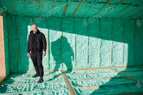 Preview: Man inspecting quality of building wooden frame house.