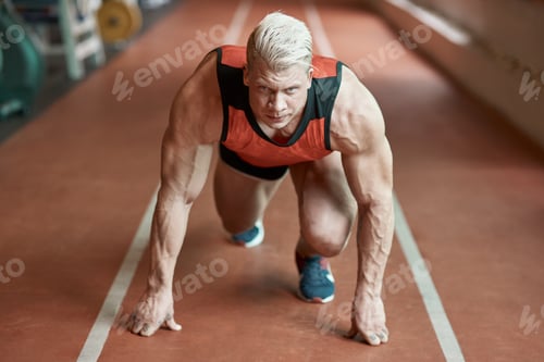 Preview: Confident male sprinter standing on a start position