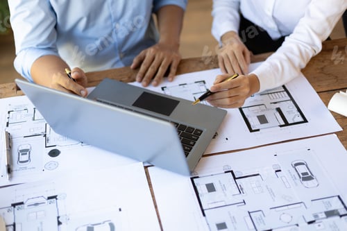 Preview: Architect and engineer discuss building blueprint design on laptop and construction project planning