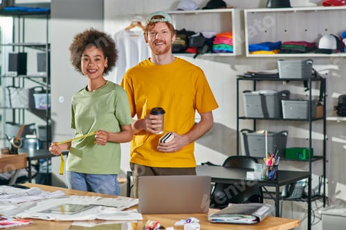 Preview: Positive multiethnic craftspeople holding coffee to go and tape measure while looking at camera