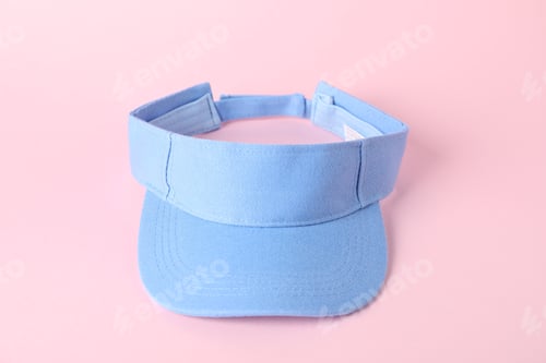 Preview: One light blue visor cap on pink background, closeup. Mockup for design