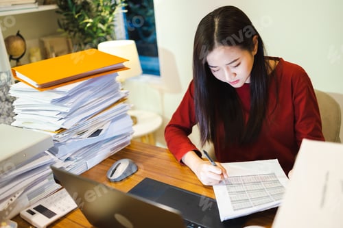 Preview: Businesswoman make the business reports by computer laptop during overtime at home