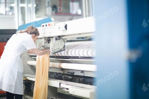Preview: Woman working at machinery in laundry