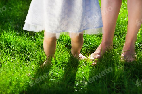 Preview: Baby girl taking first steps with mother help