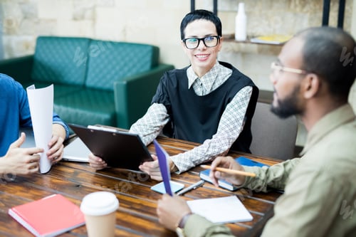 Preview: Confident female creative specialist talking to colleagues