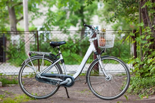Preview: White city woman bicycle with a pineappple in basket in sunny day