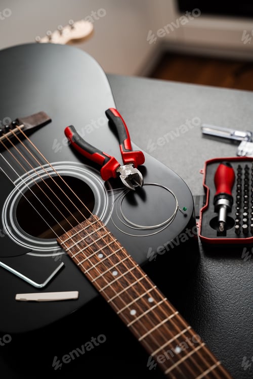 Preview: Guitar string replacement with tools. Acoustic guitar setup in progress with new strings