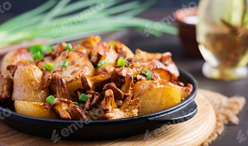 Preview: Baked potatoes with garlic, herbs and fried chanterelles in a cast iron skillet.
