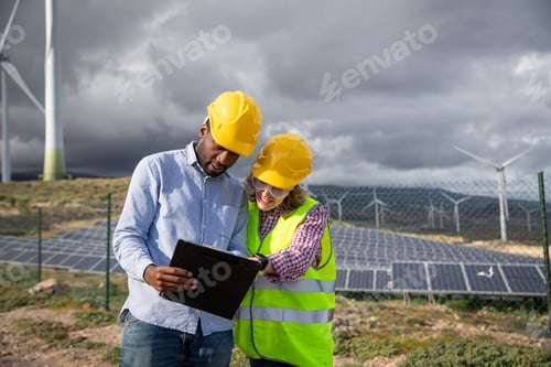 Preview: Two colleagues consult documents while at a photovoltaic power station