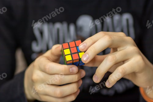 Preview: Child wearing casual clothes solving Rubik's Cube.