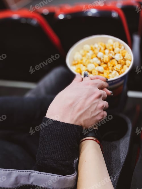 Preview: Romantic Couple Holds Hands at the Movie Theater