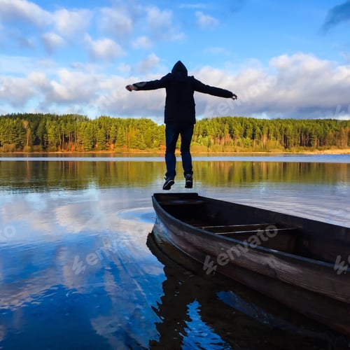 Person Jumping from Boat on Lake