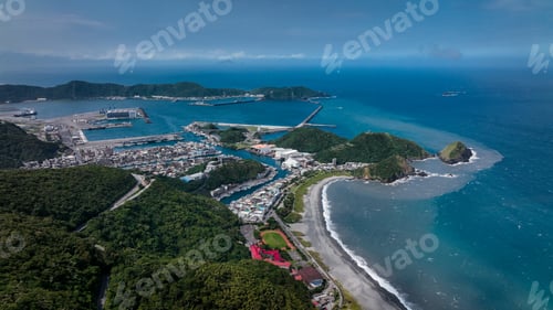 Preview: Aerial view of a coastal town in Taiwan showcasing mountains, harbor, and clear blue waters