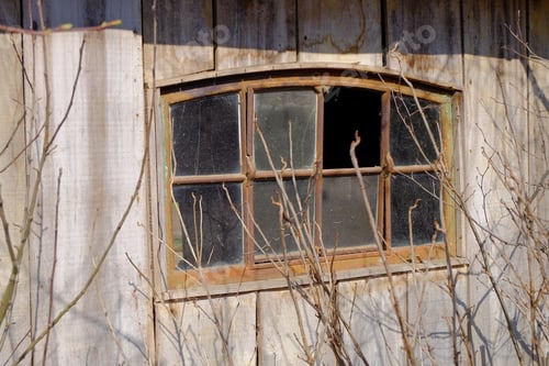 Preview: Closeup shot of the windows of a house made of wooden walls in front of tree branches