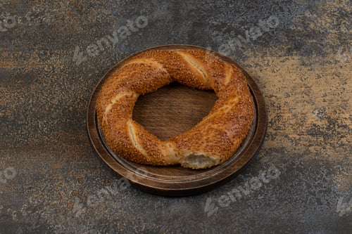 Preview: Delicious simit with sesame seeds on wooden plate