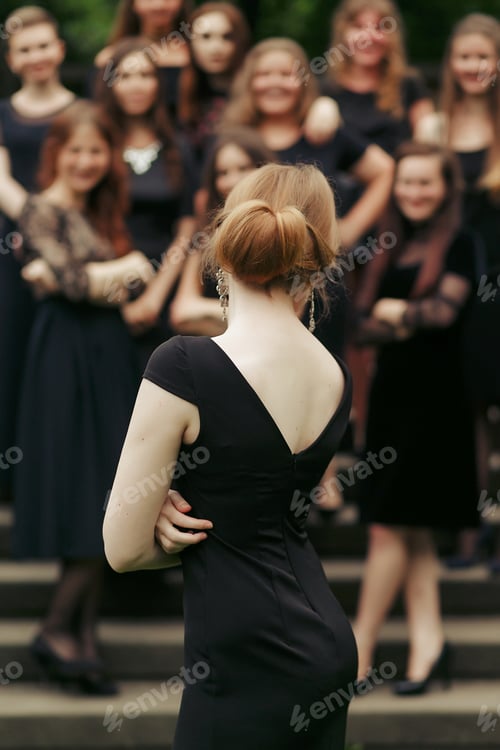Preview: luxury gorgeous woman in black dress posing, standing in front of group of ladys