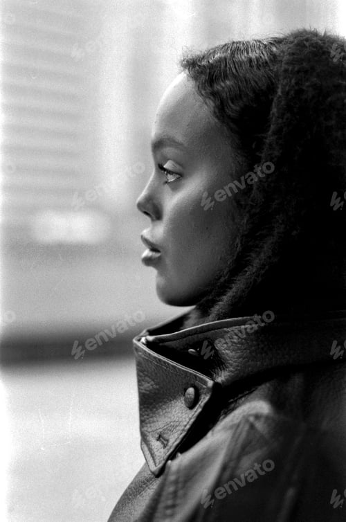 Preview: Woman wearing leather jacket looking away with film grain