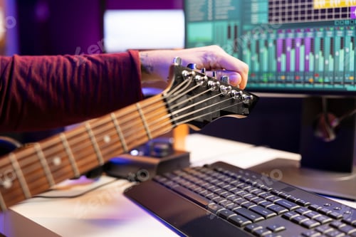 Preview: Talented singer tuning his guitar strings for a new audio recording session