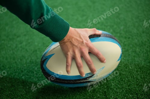 Preview: Cropped hand holding rugby ball