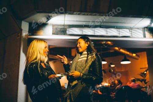 Visualização: Mulher loira e mulher asiática se divertem.