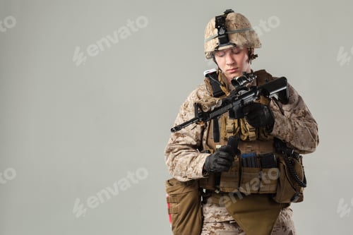 Preview: Soldier in military uniform holds weapon in studio setting during training session