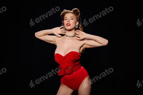 Preview: Stunning young woman in chic red attire strikes a fashionable pose against a dark backdrop