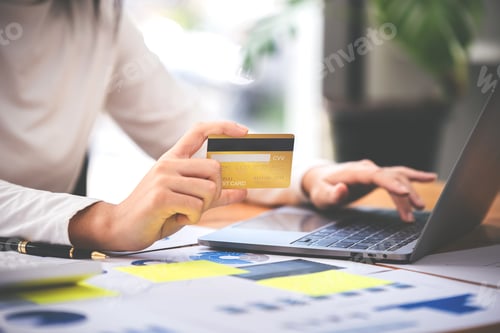 Preview: girl holding a credit card and using a laptop Business woman working from home . online shopping, ec