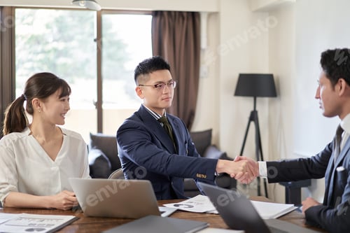 Preview: Asian businessman shaking hands with Latin