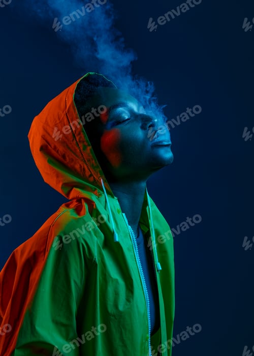 Preview: Hipster woman in raincoat blowing smoke from mouth