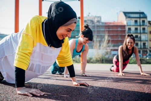 Preview: Calisthenics class at outdoor gym, young women practicing yoga position