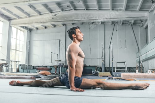 Preview: caucasian man gymnastic acrobatics equilibrium posture at gym background