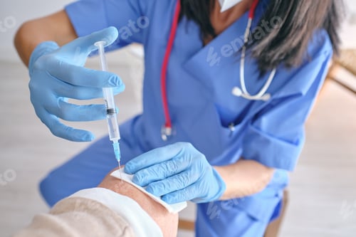 Preview: Faceless nurse in sterile gloves vaccinating patient with inject