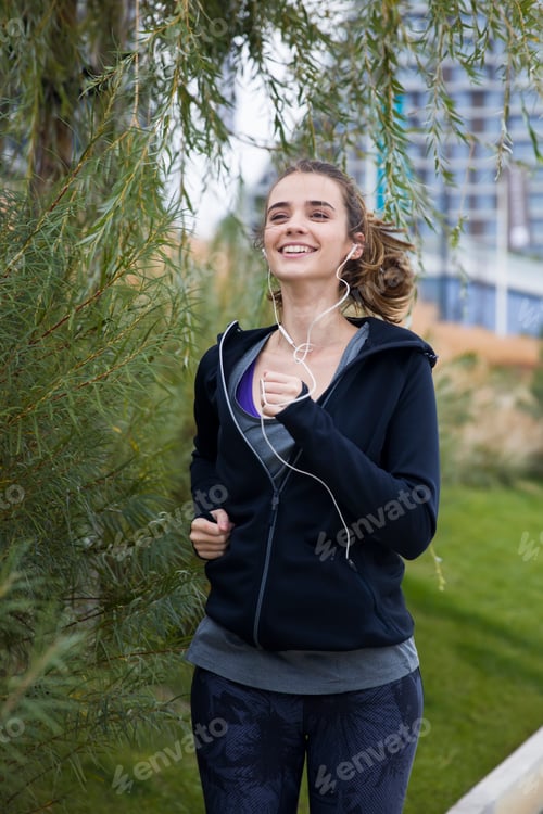 Preview: Young beautiful woman running in urban enviroment