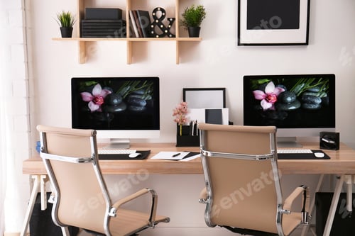 Preview: Modern workplace with large desk and computers in room. Stylish interior