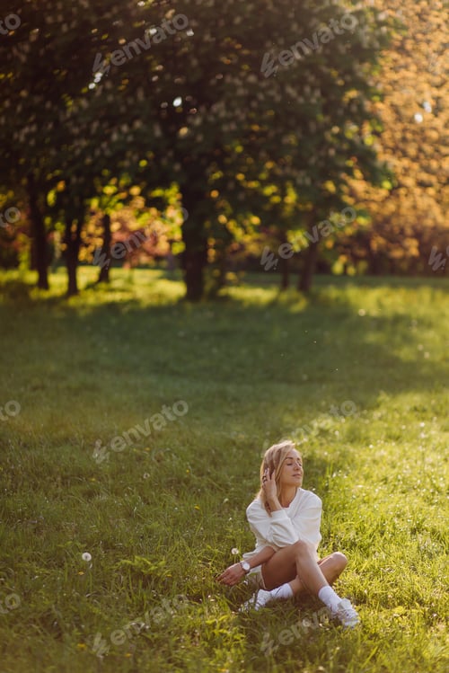 Preview: Young blonde girl is wearing a white hoodie smiling and walking in the woods