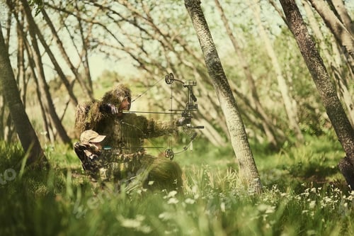 Preview: Shot of a father and son in camouflage hunting with bows and arrows in the woods