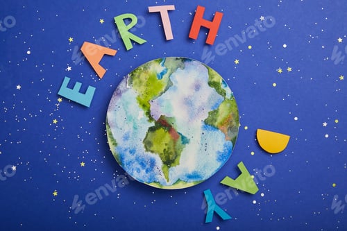 Preview: top view of colorful paper letters and planet picture on violet background with stars, earth day