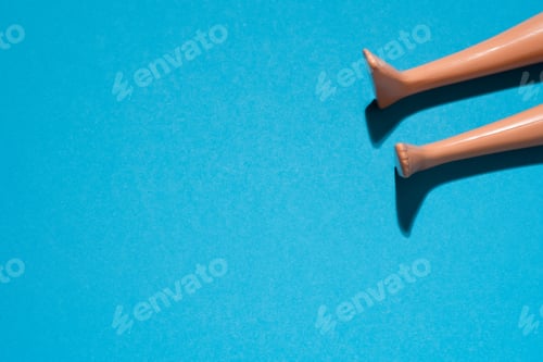 Preview: doll legs on blue paper background