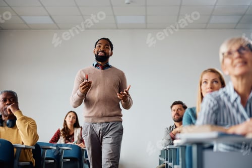 Preview: Happy black professor teaching group of adult students in the classroom.