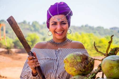 Preview: Happy african american woman opening cutting coconut with machete.