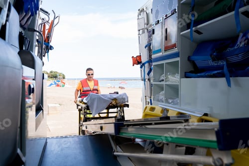 Preview: Medical worker taking a stretcher out of an ambulance