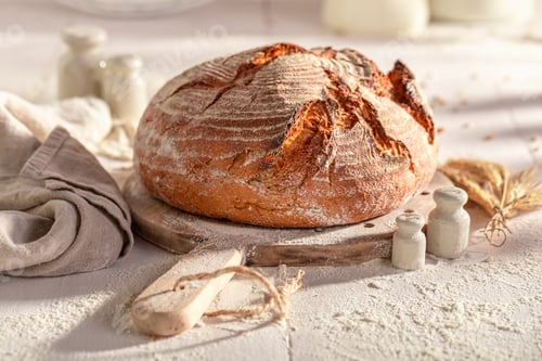 Preview: Crispy and rustic round loaf bread baking in with grain.