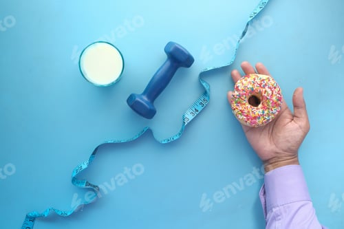 Preview: measuring tape wrapped around a dumbbell and donuts on table