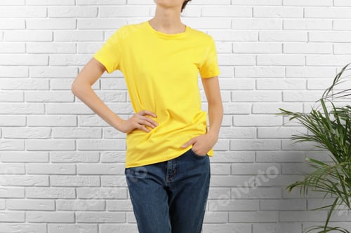 Preview: Woman in bright t-shirt near brick wall. Mock up for design
