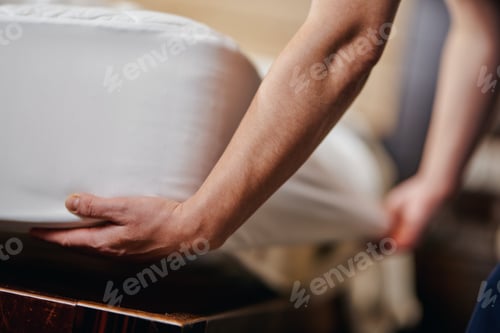 Preview: Housekeeper is changing bedding in hotel room