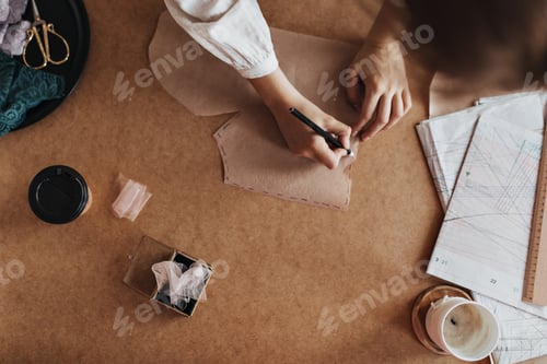 Preview: Lady create pattern for future shirt. Woman in beige blouse working on designing new fashionable te
