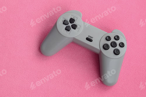 Preview: Playing games concept. Single pad joystick lies on the blanket of furry pink fleece fabric