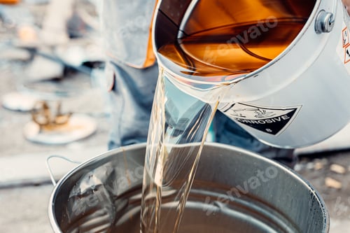 Preview: Construction worker pouring epoxy resin into metal bucket